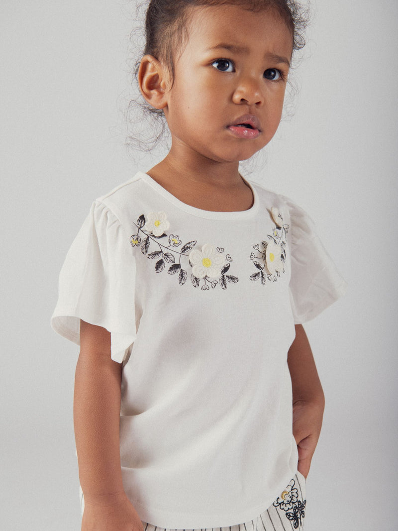 Camiseta ecru bordada com flores e mangas de ondas para menina