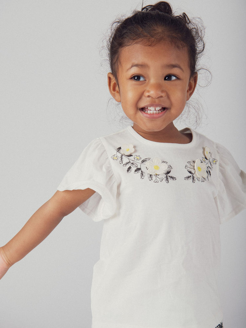 Camiseta ecru bordada com flores e mangas de ondas para menina