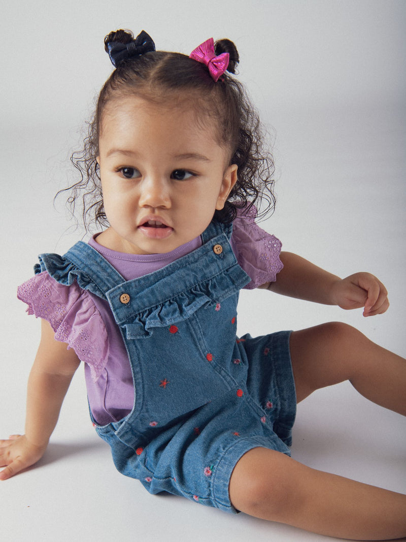 Salopette curta em denim com bordados florais e frutais para menina