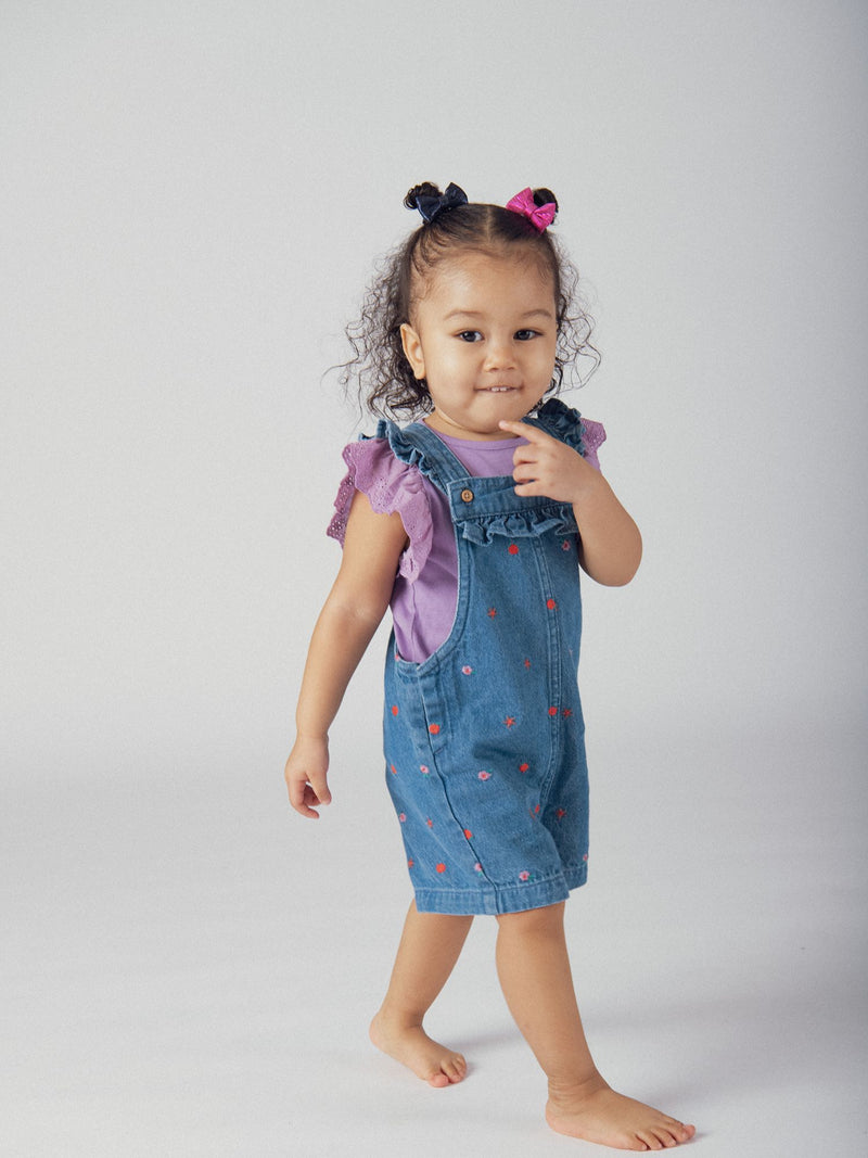 Salopette curta em denim com bordados florais e frutais para menina