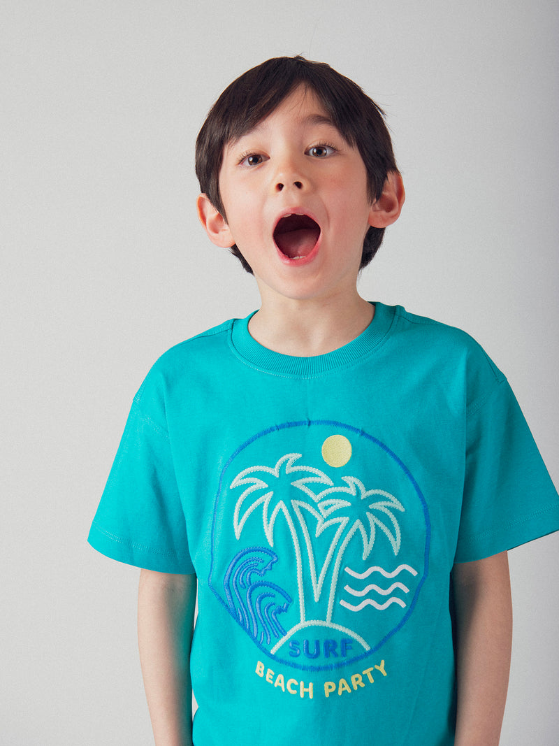 T-shirt azul turquesa com animação de praia para menino