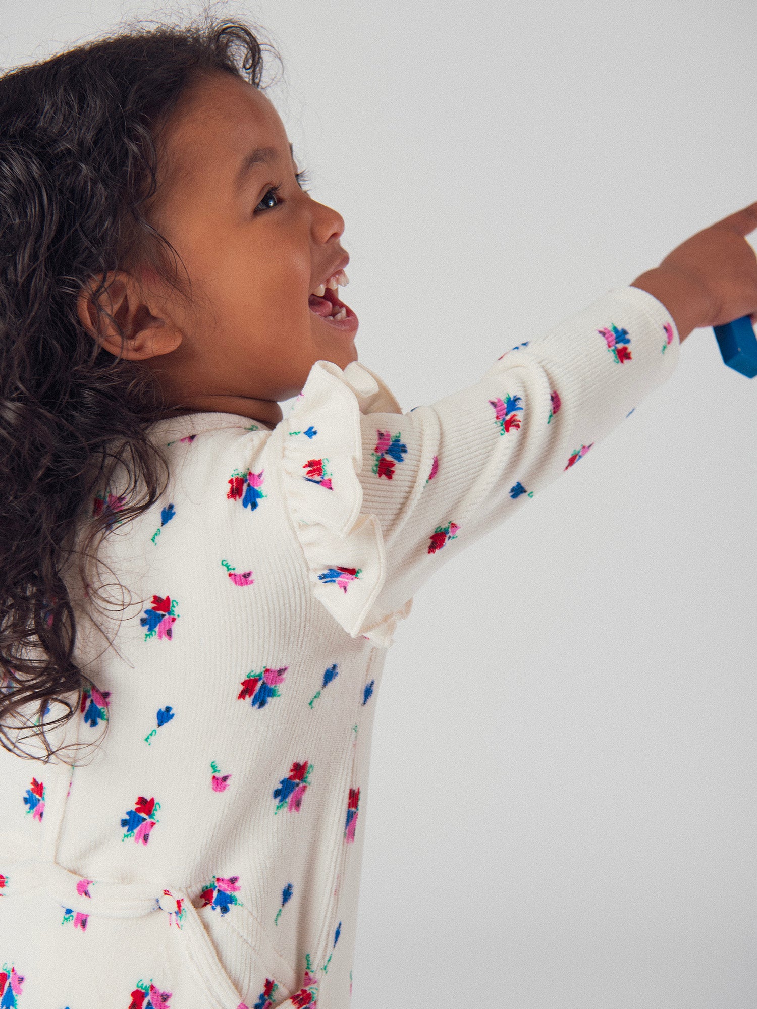 Macacão creme com folhos e padrões de pequenos pássaros e flores para menina